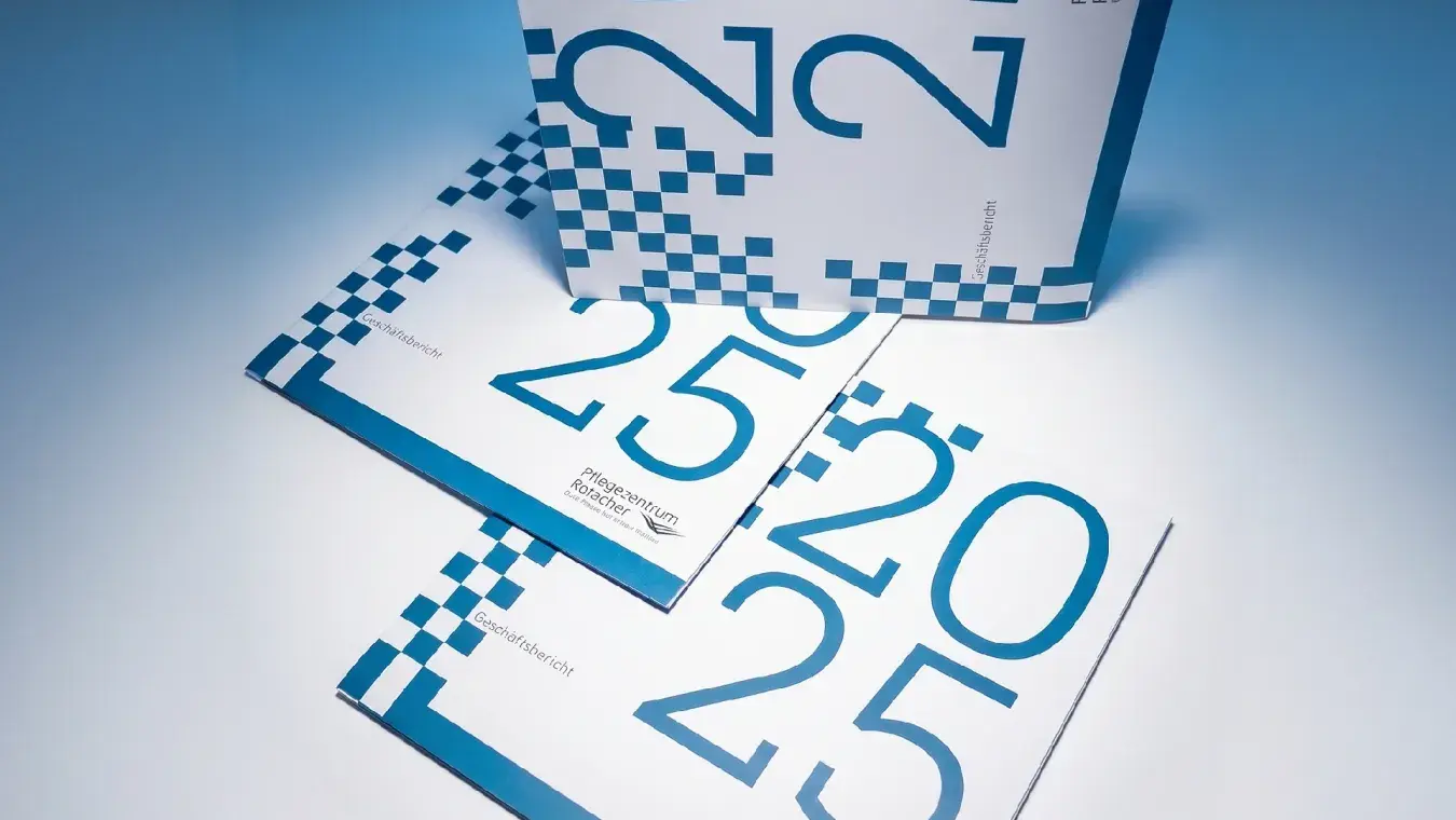 Geschäftsbericht 2025 Pflegezentrum Rotacher, Cover-Stapel mit blauer Pixel-Optik im Studio
